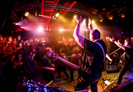 two musicians on stage at a concert clapping their hands